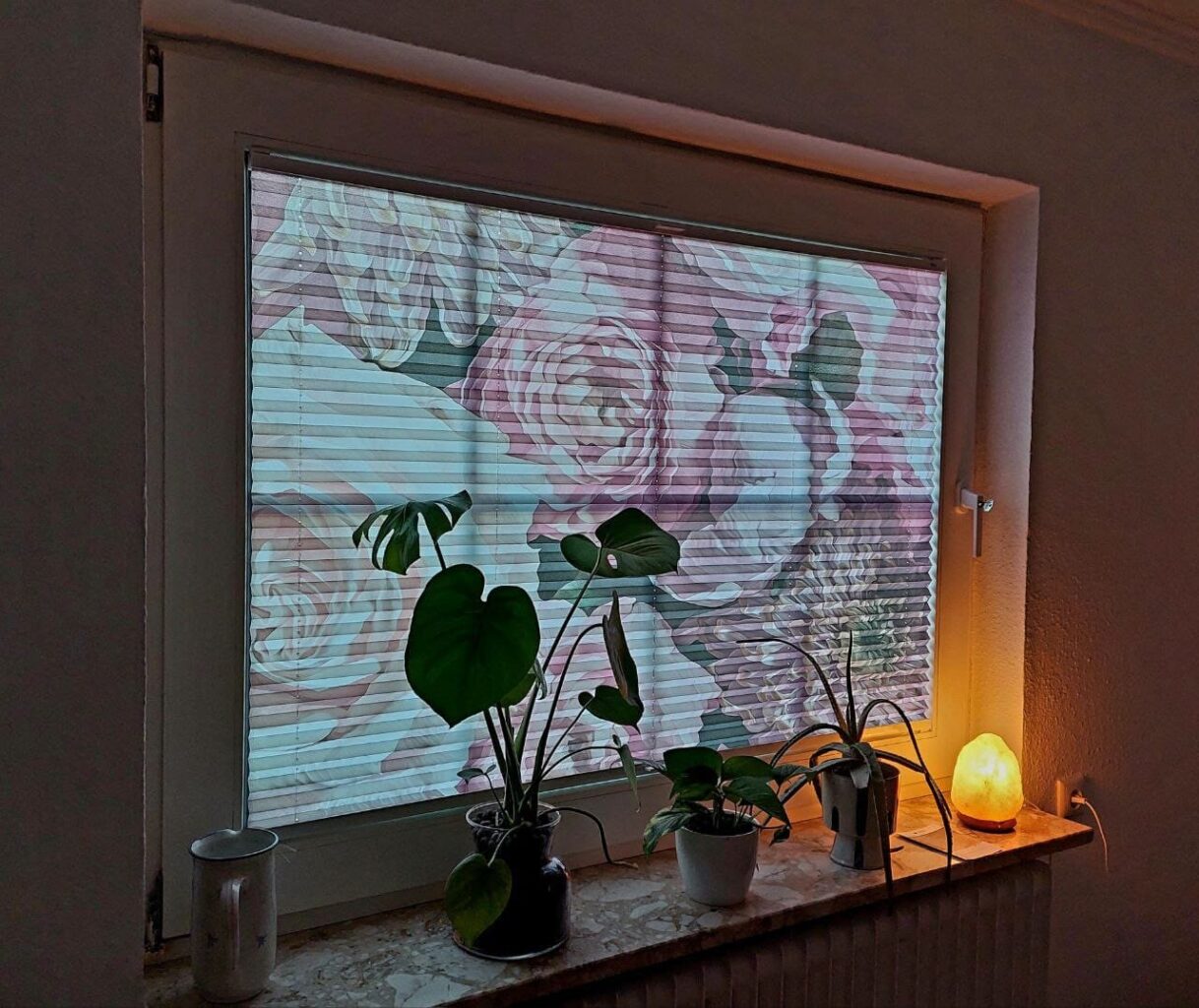 Plissee mit floralem Digitaldruck als Gestaltungselement im Wohnraum.
