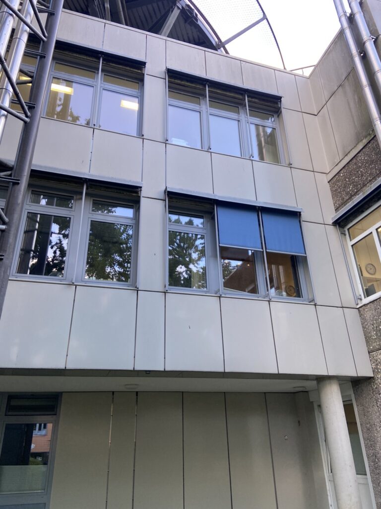 Senkrechtmarkise an einem Bürogebäude.