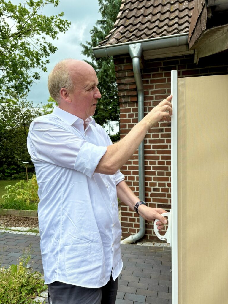 Dennis Witschel erklärt technische Details einer Sonnenschutzanlage.